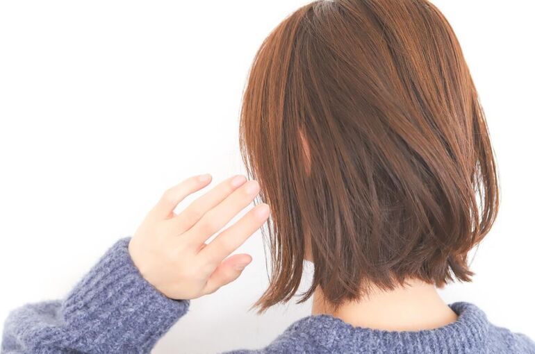 セーターを着たショートカット女性の後ろ姿